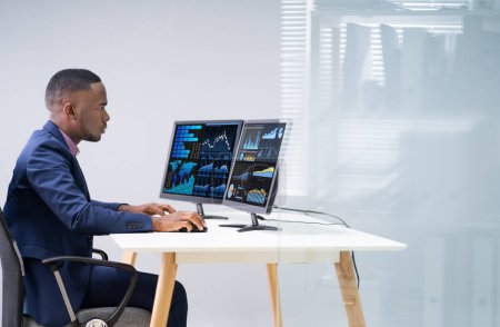 Téléchargez les photos : Vue latérale de deux hommes d'affaires examinant le graphique sur l'ordinateur sur le lieu de travail - en image libre de droit