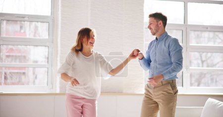 Téléchargez les photos : Couple familial excité dansant. Les gens dansent à la maison - en image libre de droit