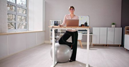 Foto de Mujer usando altura ajustable de pie escritorio en la oficina para una buena postura - Imagen libre de derechos