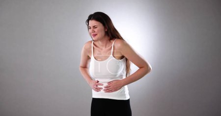 Foto de Mujer que sufre de dolor de estómago. Dolor de barriga - Imagen libre de derechos