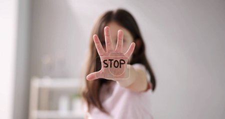 Nahaufnahme der Hand eines Mädchens, die ein Stoppschild zeigt