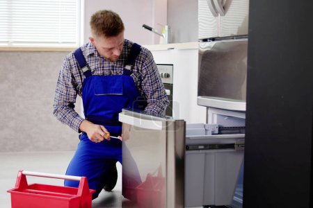 Téléchargez les photos : Technicien électricien travaillant pour réparer le réfrigérateur ou l'appareil de réfrigérateur - en image libre de droit