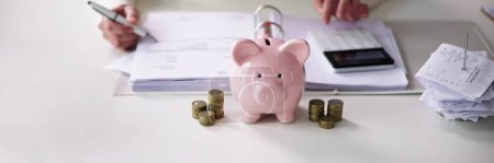 Foto de Asesor financiero con Piggybank. Cálculo del ahorro de dinero - Imagen libre de derechos