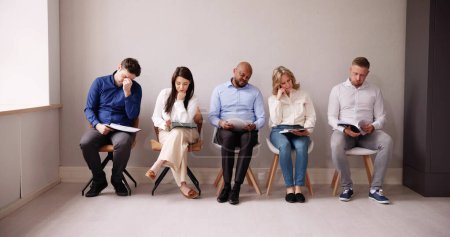 Foto de La gente de negocios se aburre mientras está sentada en la silla esperando una entrevista de trabajo en la oficina - Imagen libre de derechos