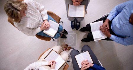 Téléchargez les photos : Groupe de personnes lisant ensemble un livre religieux - en image libre de droit