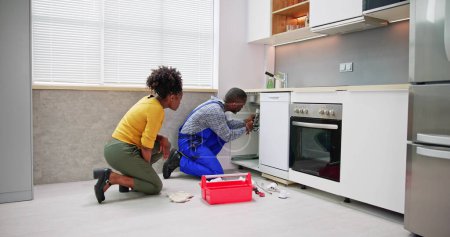 Téléchargez les photos : Drain de nettoyage de plombier et tuyau dans la cuisine - en image libre de droit