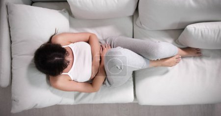 Foto de Mujer enferma con dolor abdominal del período de la hormona del PMS - Imagen libre de derechos