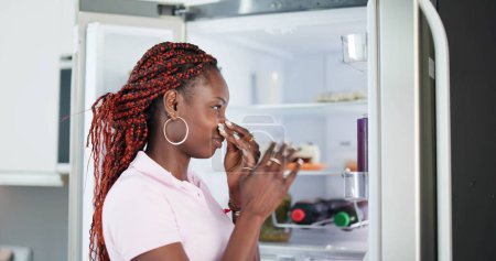 Téléchargez les photos : Jeune femme reconnue mauvaise odeur venant du réfrigérateur - en image libre de droit