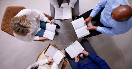Téléchargez les photos : Groupe de personnes lisant ensemble un livre religieux - en image libre de droit