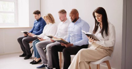 Téléchargez les photos : Les gens assis dans une rangée de lecture de la Bible - en image libre de droit