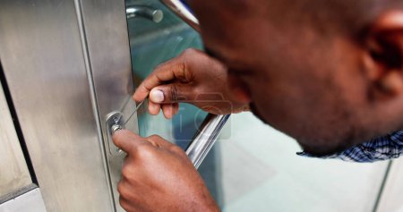 Photo for Locksmith Workman Repairing Lock. Lockpicker Worker At Door - Royalty Free Image