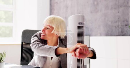 Foto de Ventilador eléctrico del ventilador en la oficina caliente que sopla brisa fresca - Imagen libre de derechos