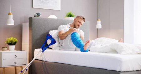 Téléchargez les photos : Homme avec fracture de jambe fracture et fonte à l'aide de béquilles - en image libre de droit