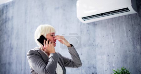 Foto de Reparación de aire acondicionado roto. Mujer llamando al servicio de reparación - Imagen libre de derechos