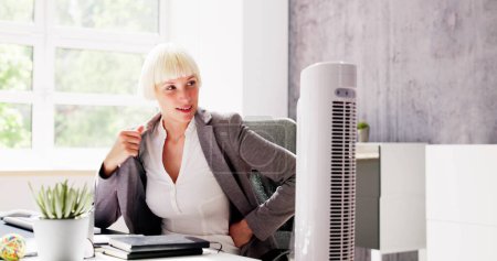 Photo for Electric Ventilator Fan In Hot Office Blowing Cool Breeze - Royalty Free Image