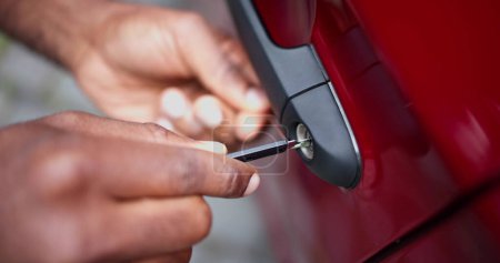 Photo for Close-up Of Person's Hand Opening Car Door With Lockpicker - Royalty Free Image