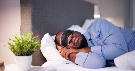 Photo for Young African Man Sleeping With Sleep Mask - Royalty Free Image