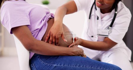 Téléchargez les photos : Pregnant Woman Massage By Doula. Baby Care And Pregnancy Service - en image libre de droit