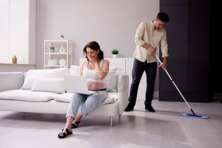 Photo for Man Helping Pregnant Wife. Cleaning House. Young Couple - Royalty Free Image