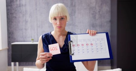 Photo for Woman Using Menstrual Cycle Or Period Calendar - Royalty Free Image