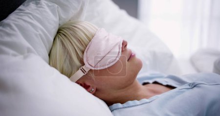 Foto de Mujer joven durmiendo con la máscara del sueño en el dormitorio - Imagen libre de derechos