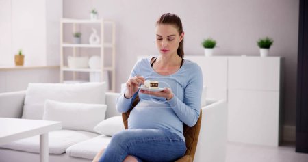 Foto de Mujer embarazada comiendo comida de postre. Momento divertido - Imagen libre de derechos