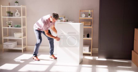 Photo for Man Carrying Furniture At Home. Move And Relocation - Royalty Free Image
