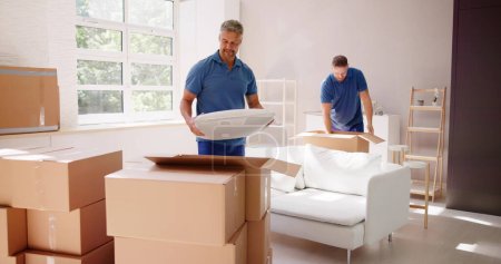 Téléchargez les photos : Emballeurs et déménageurs chez eux. Livraison de meubles résidentiels - en image libre de droit