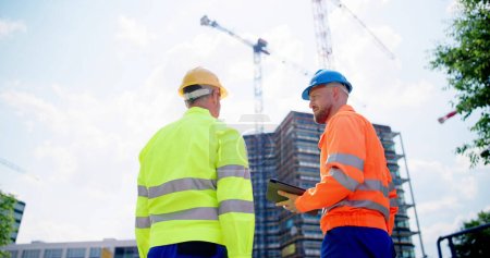Téléchargez les photos : Ingénieur d'inspection Travailleur sur chantier utilisant une tablette - en image libre de droit