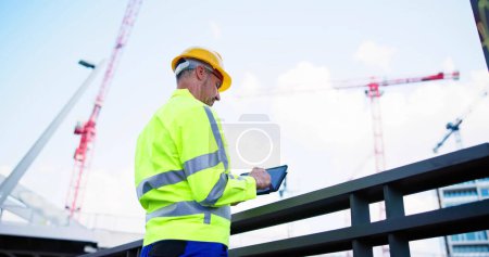 Téléchargez les photos : Inspecteur OSHA sur le chantier. Jeune ouvrier ingénieur - en image libre de droit