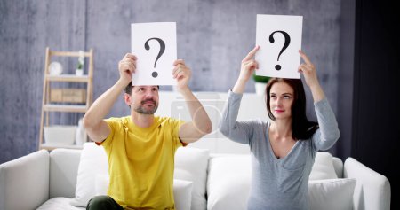 Photo for Couple In The Living Room With Question Marks - Royalty Free Image