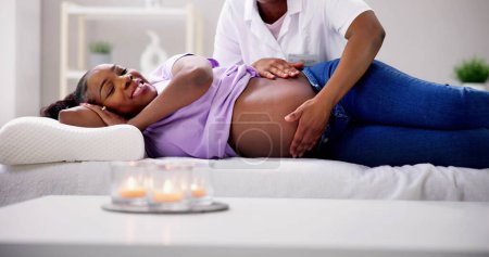 Téléchargez les photos : Massage de grossesse et physiothérapie par un médecin - en image libre de droit