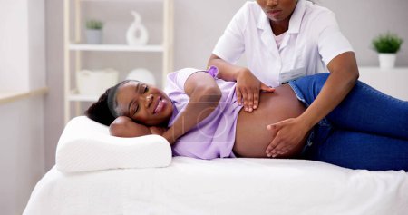 Téléchargez les photos : Massage de grossesse et physiothérapie par un médecin - en image libre de droit