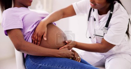 Téléchargez les photos : Pregnant Woman Massage By Doula. Baby Care And Pregnancy Service - en image libre de droit