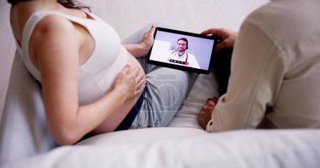 Foto de Embarazada pareja en línea videollamada con médico - Imagen libre de derechos