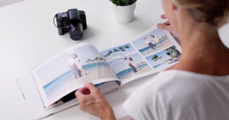 Téléchargez les photos : Femme regardant l'album photo ou le livre photo - en image libre de droit