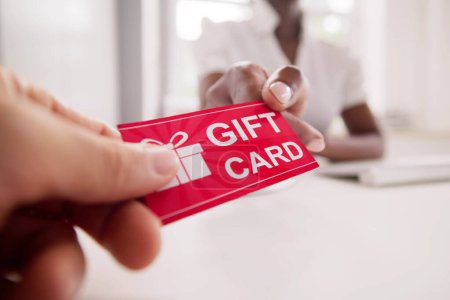 Foto de Holding Giving Gift Card Voucher And Ticket - Imagen libre de derechos