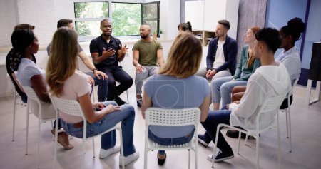 Photo for Young Multiracial Millennial Friends Sitting In Circle Having Group Discussion - Royalty Free Image