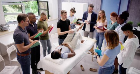 Téléchargez les photos : Instructeur masculin enseignant la technique de massage au groupe de personnes multi-ethniques - en image libre de droit