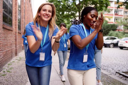 Téléchargez les photos : Happy Women In Volunteer Uniform Dancing To Music. Communauté amusante - en image libre de droit