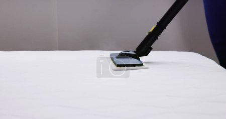 Photo for Cleaning Bed Mattress With Steam Machine. Bed Bugs Treatment - Royalty Free Image