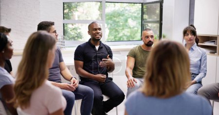 Jeunes amis multiraciaux du millénaire assis en cercle ayant une discussion de groupe
