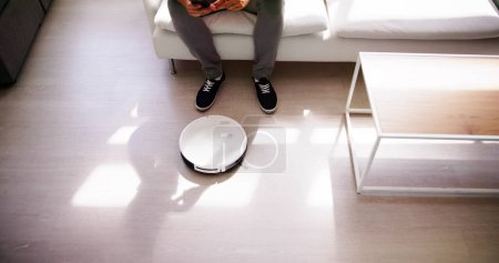 Foto de Casa Robot Cleaner Hacer tareas domésticas cerca del sofá - Imagen libre de derechos