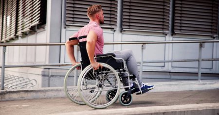 Téléchargez les photos : Homme ayant un handicap physique en fauteuil roulant sur la rampe à l'extérieur - en image libre de droit