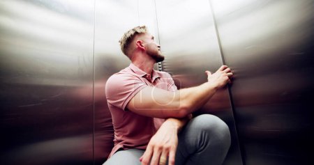 Photo for Man Suffering From Claustrophobia Trapped Inside Elevator Screaming - Royalty Free Image