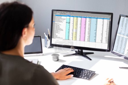 Téléchargez les photos : Vue latérale de la main de femme d'affaires analysant des données sur l'ordinateur sur le bureau - en image libre de droit