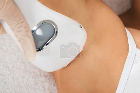 Téléchargez les photos : Gros plan de la jeune femme recevant un traitement laser d'épilation sur l'aisselle - en image libre de droit