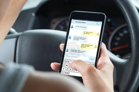 Foto de Primer plano de la mujer sentada dentro del coche escribiendo mensaje de texto en el teléfono móvil - Imagen libre de derechos