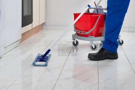 Téléchargez les photos : Gros plan du sol de nettoyage des travailleurs avec de la serpillière dans la salle de cuisine - en image libre de droit