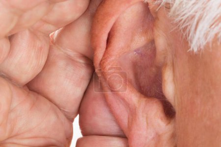 Téléchargez les photos : Gros plan d'un homme âgé essayant d'entendre la main sur l'oreille - en image libre de droit